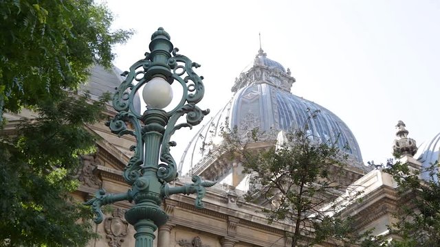 Travel Bucharest, Romania - Close up view of a historic street lamp in the city center with impressive architecture in the background
