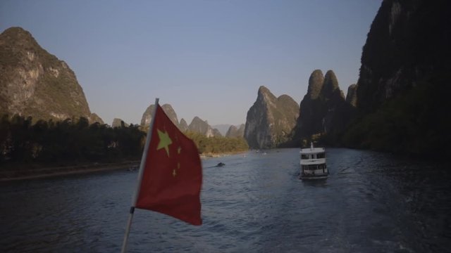 Brilliant view of mountains and Chinese flag from Guilin, Mainland China on the Li River.