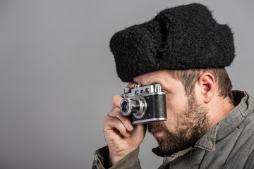 Bearded man with retro camera, studio shott. Old-fashioned clothing, retro style. Photography of the 50th