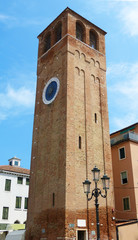 Fototapeta na wymiar Bell tower of Chioggia with the historical clock of Saint Andrews, Italy