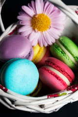 Sweet and colourful french macaroons in the basket.