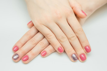 Hands with long artificial manicured nails colored with red nail polish