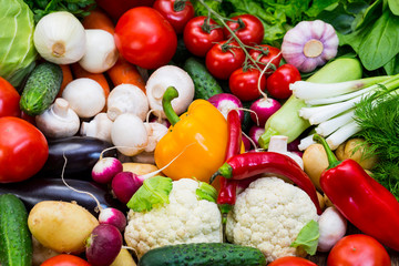 Fresh vegetables background close-up of tomatoes, cucumbers, onions, mushrooms 