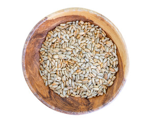 roasted peeled sunflower seeds in wooden dish isolated on white background top view