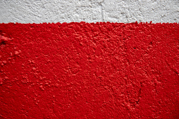White and red painted wall photo. Painted brushed texture. Grungy concrete wall closeup. Rustic architecture background.
