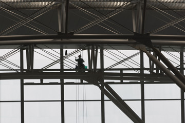 Fototapeta premium Window Cleaner with green bucket seen from inside building