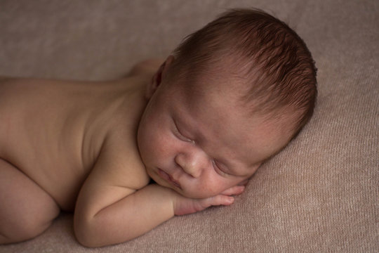 the first photo shoot. newborn child. newborn boy. the child lies on a beige blanket