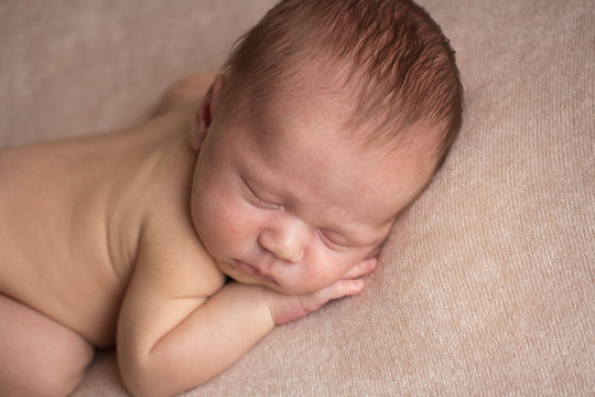 the first photo shoot. newborn child. newborn boy. the child lies on a beige blanket