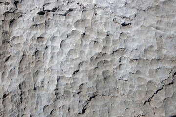 White rock rough texture. Stone surface photo. Chipped stone surface with cutter marks. Aged stone wall closeup.