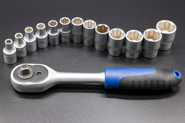 Set of hand tools - socket wrench with heads on gray background