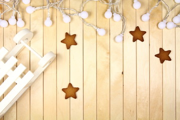 Świąteczna dekoracja - Xmas - białe sanki, lamki i pierniki na drewnianym blacie - obrazy, fototapety, plakaty