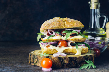 Fresh big ciabatta sandwich stuffed with prosciutto