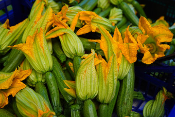 Zucchini flower blossoms in a crate at an Italian farmers market