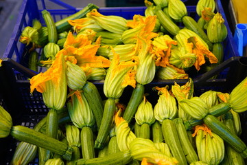Zucchini flower blossoms in a crate at an Italian farmers market