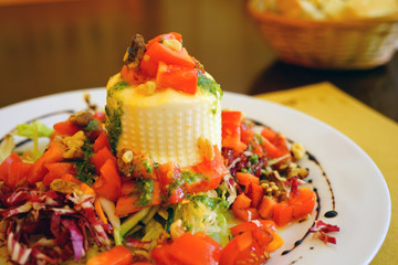 Plate of fresh burrata cheese with a tomato salad