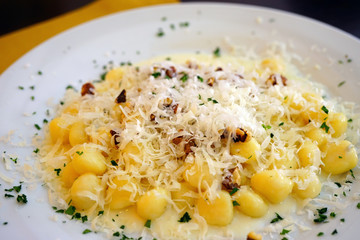 Plate of Italian potato gnocchi with gorgonzola cheese and walnuts