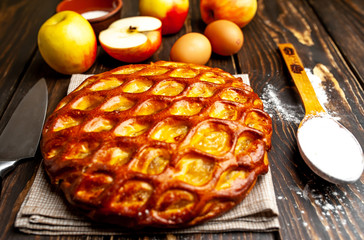 Fresh baked organic classic American apple pie with raisins, on a wooden table. Rustic style.