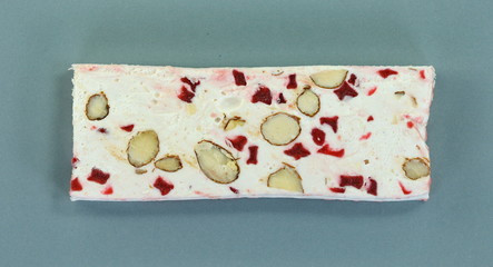French soft nougat with strawberry flawour and almonds isolated on white background. Greek manolato.