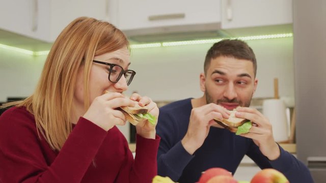 Couple eating sandwiches