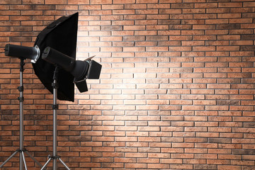 Professional lighting equipment near wall in photo studio. Space for text