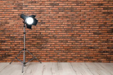 Professional lighting equipment near wall in photo studio. Space for text