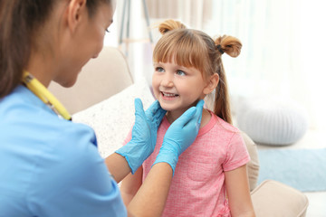 Children's doctor visiting little girl at home