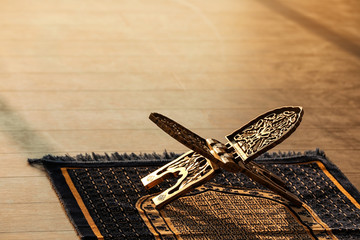 Rehal for Quran on Muslim prayer mat indoors