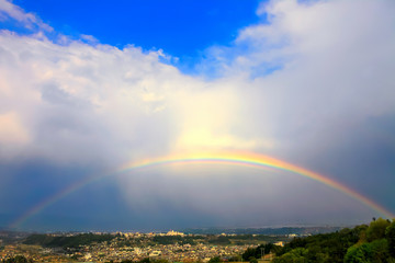 Fototapeta na wymiar 河岸段丘の街並みに架かる虹
