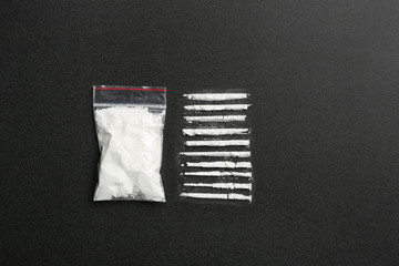 Flat lay composition with cocaine powder on black background. Space for text