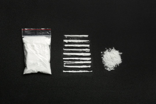 Flat lay composition with cocaine powder on black background