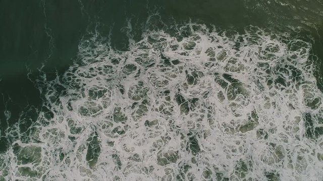 Powerful Ocean Seascape from Above. Sand Churning in the White Water of Crashing Waves. Cinematic