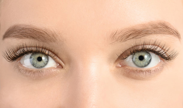 Young woman with beautiful long eyelashes, closeup. Extension procedure