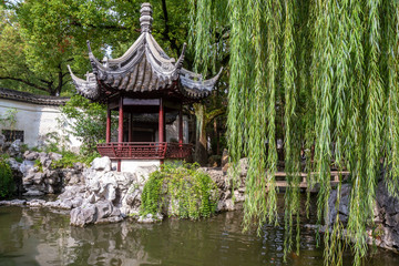 Pavilion, rocks and willow tree in Yu Yuan Garden, Shanghai China. © Patrick
