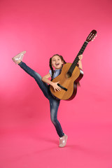 Obraz premium Cute little girl playing guitar on color background