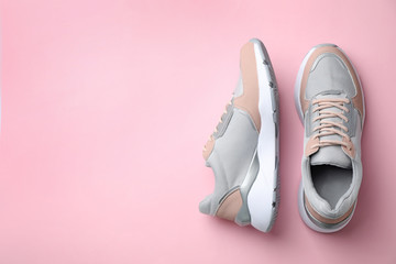 Pair of stylish sneakers on color background, top view. Space for text