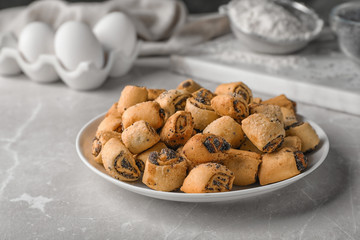 Tasty sweet cookies with poppy seeds on gray table