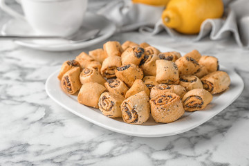 Tasty sweet cookies with poppy seeds on marble table