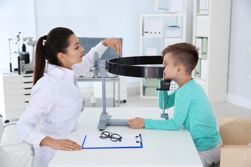 Children's doctor examining little boy's vision in clinic