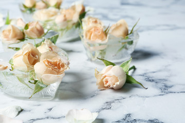 Heart shaped ice cubes with roses on marble background