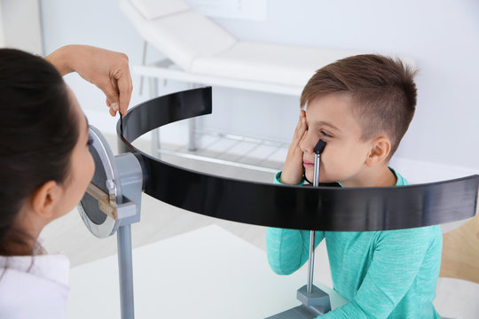 Children's doctor examining little boy's vision in clinic