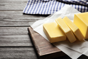 Wooden board with fresh butter on table. Space for text