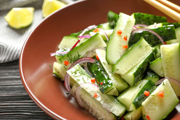 Delicious cucumber salad with onion on plate, closeup
