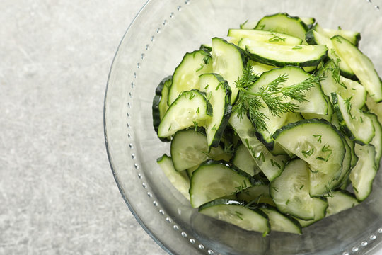 Delicious cucumber salad with dill in bowl on grey background, top view
