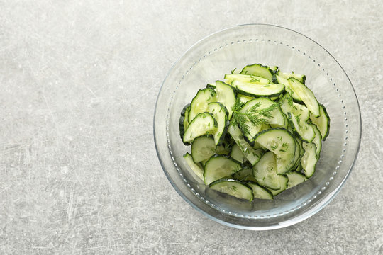Delicious cucumber salad with dill in bowl on grey background, top view. Space for text