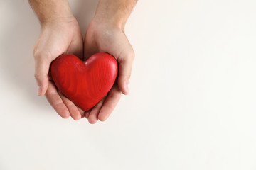 Man holding decorative heart on white background, top view with space for text