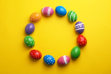 Decorated Easter eggs and space for text on color background, top view