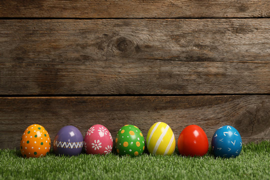 Decorated Easter eggs on green grass. Space for text