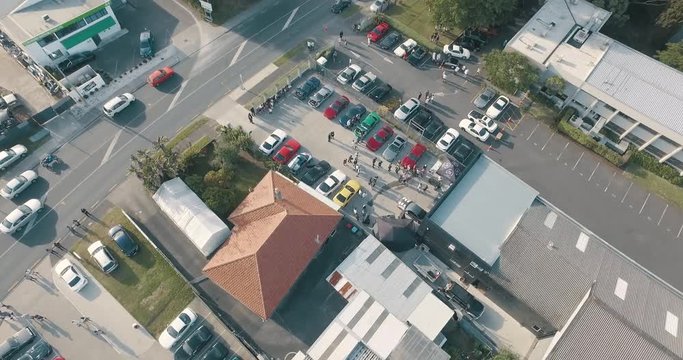Wide Aerial Establishing Shot of a Gathering of People at a Small Car Meet.