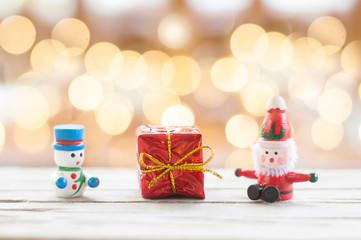 Santa Claus, Snowman doll and red gift box with shiny light for Christmas decoration background