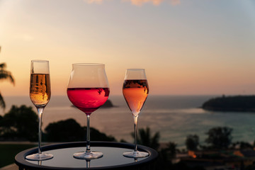 Different kind of cocktail glass, a glass of champagne, red wine and rose wine with sunset background, festive celebration. Christmas festive celebration. End of the year, Welcome start New Year 2019 